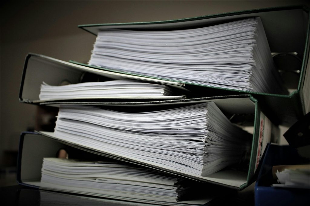 Close-up of stacked binders filled with documents for office or educational use.